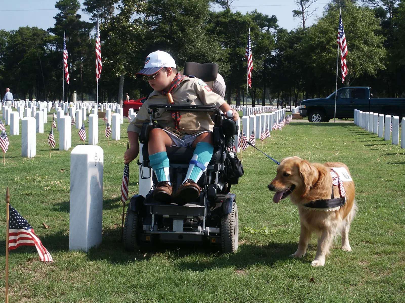 A Boy Scout places an American flag at a grave at Barrancas National Cemetery in Pensacola, Florida, before Memorial Day.