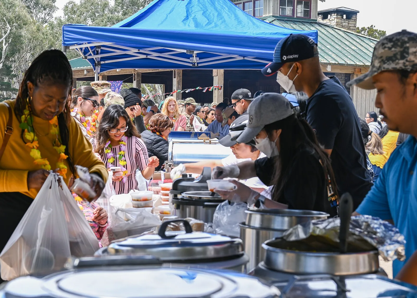 Guests line up for food samples under a tent at a food tasting event at Vandenberg Space Force Base, Calif.