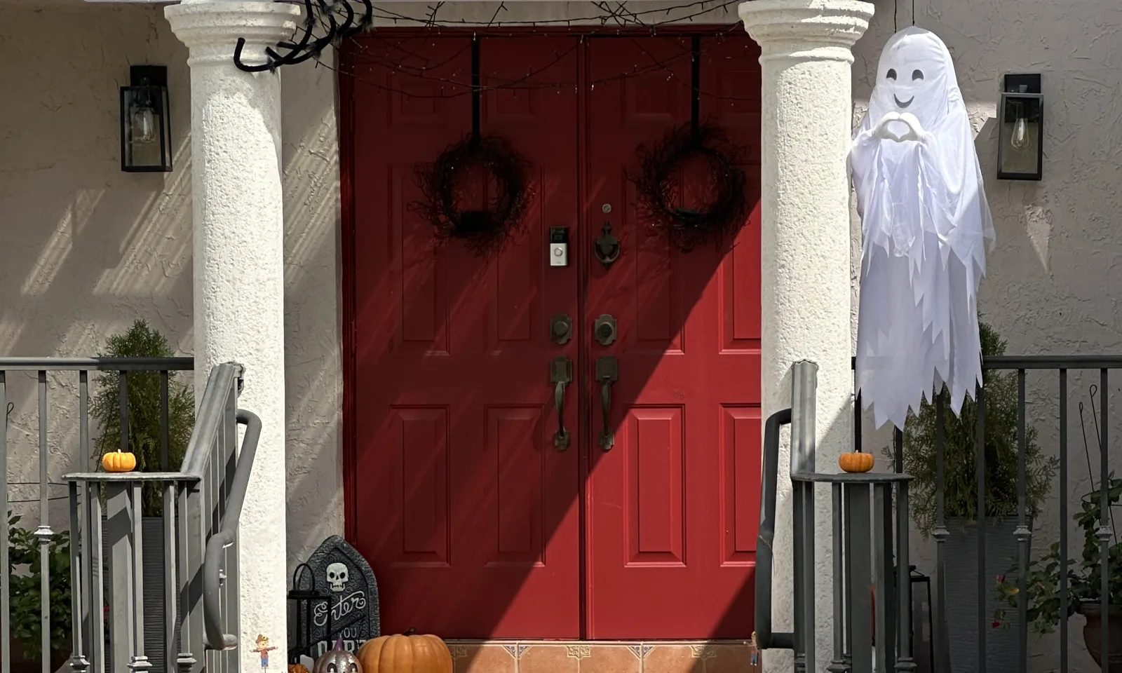 A ghost, a giant spider and pumpkins decorate a front porch for Halloween in West Miami, Florida.