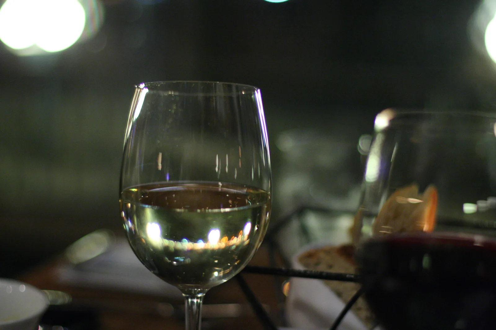Glasses of white and red wine catch the light on a restaurant table in Victoria, British Columbia.